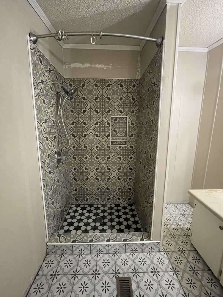 Modern bathroom shower with patterned tile walls and penny tile floor