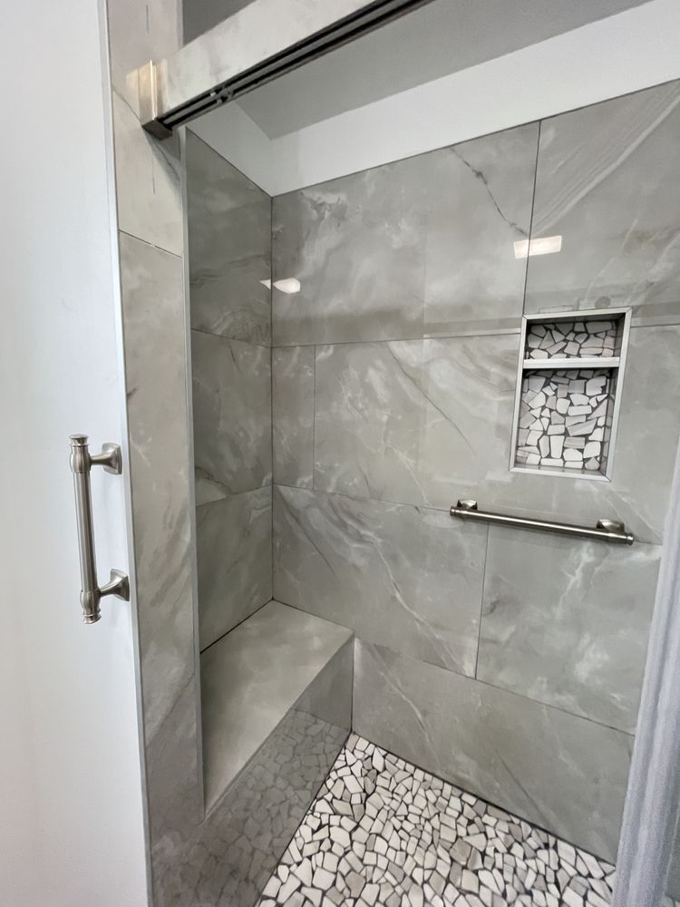 Modern shower enclosure with gray marble tile walls and white mosaic floor