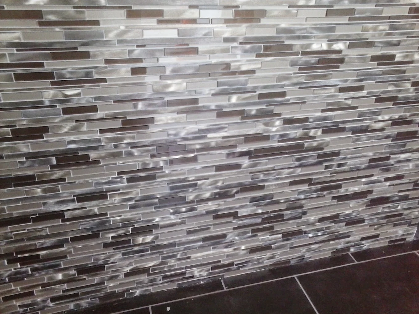 Modern glass and stone subway tile backsplash in neutral gray and brown tones
